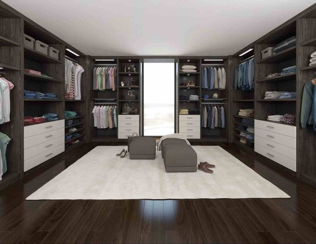 Custom walk-in closet design by a custom closet manufacturing partner featuring built-in shelving, drawers, hanging space, and organized clothing storage in a modern home interior.